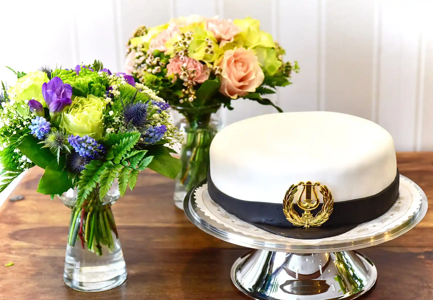 Ylioppilaslakin muotoinen kakku ja kukat